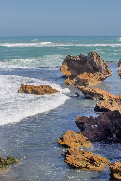 Keskin kıyı kaya oluşumları ve turkuaz okyanus dalgaları Güney Avustralya 'nın engebeli kıyı şeridinde buluşuyor.