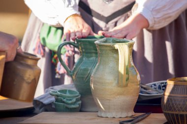 Geleneksel açık hava pazarında sergilenen hasır sepette el yapımı kase, bardak ve sürahi çeşitleri