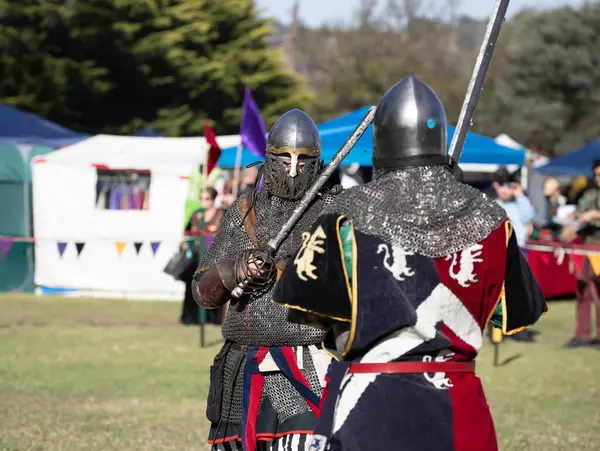 Paracombe, Güney Avustralya 05.03.2025. Güney Avustralya 'daki Ortaçağ Fuarı' nda kılıçlar ve kalkanlarla yapılan yeniden canlandırma turnuvasında zırhlı şövalyeler düello yapıyor.