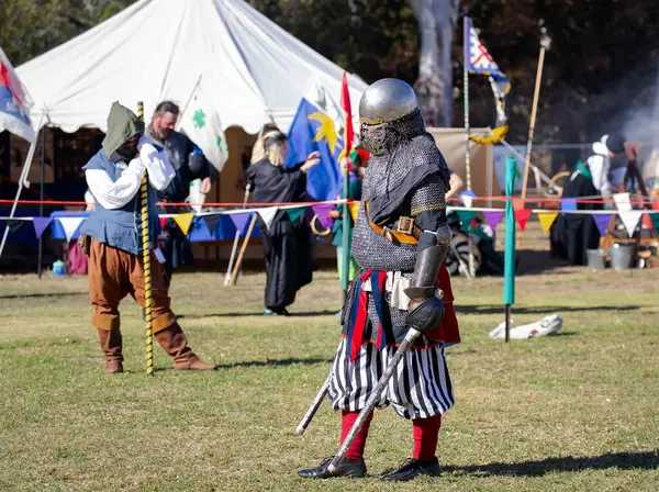 Paracombe, Güney Avustralya 05.03.2025. Güney Avustralya 'daki Ortaçağ Fuarı' nda kılıçlar ve kalkanlarla yapılan yeniden canlandırma turnuvasında zırhlı şövalyeler düello yapıyor.