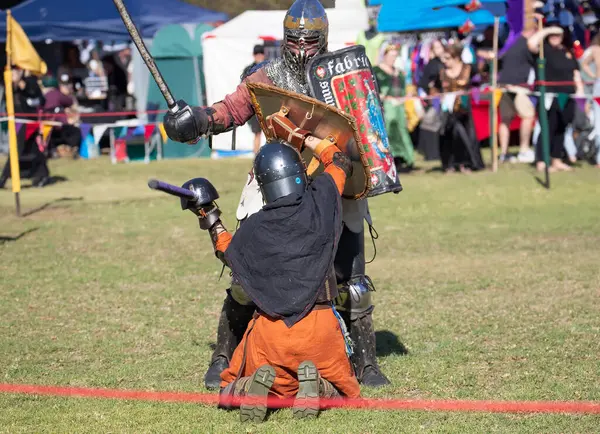 Paracombe, Güney Avustralya 05.03.2025. Güney Avustralya 'daki Ortaçağ Fuarı' nda kılıçlar ve kalkanlarla yapılan yeniden canlandırma turnuvasında zırhlı şövalyeler düello yapıyor.