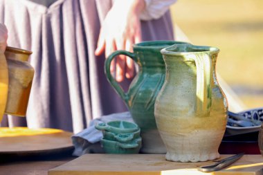 Geleneksel açık hava pazarında sergilenmekte olan hasır bir sepette el yapımı kase, bardak ve sürahi çeşitleri. Yüksek kalite fotoğraf