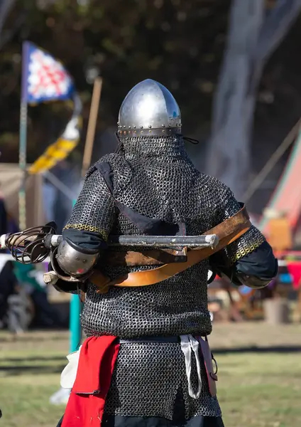 Güney Avustralya 'daki Ortaçağ Fuarı' nda zırhlı şövalye, çadırlar, bayraklar ve yerel halk etkinliğinin katılımcılarıyla çevrili. Yüksek kalite fotoğraf