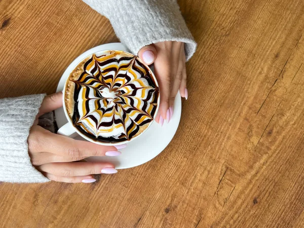 Köpüklü Örümcek Ağı Desenli Kahve Beyaz Bardakta Kızların Elleri Ahşap — Stok fotoğraf