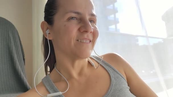 Dziewczyna Słucha Muzyki Bezprzewodowych Słuchawkach Próżniowych Uśmiechem Twarzy Domu — Wideo stockowe
