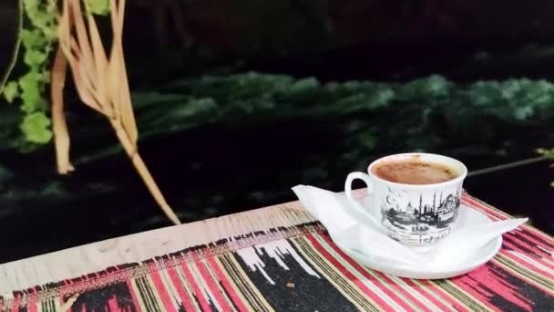 トルコ アンタルヤ 2021年9月24日 白いカップのトルコの黒い伝統的なコーヒーは 夜の川の背景に対して カフェでテーブルの上にあります — ストック動画