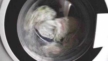 Çamaşır makinesinde çamaşır yıkama, çamaşır yıkama işlemi kapının cam kapağından görülebilir..