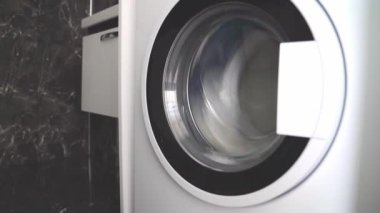 Çamaşır makinesinde bir şeyler kurutmak, yan görüş