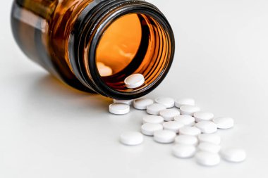 Dağıtılmış Beyaz Yuvarlak Vitaminler ve Kahverengi Şişeler, Beyaz Arkaplanda Yakın plan, İlaç Malzemeleri