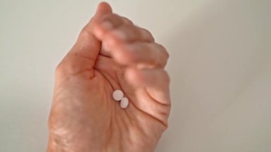 Kadın avucunda vitamin hapları tutuyor, Parmaklarını yavaşça açıyor, El ve Tabletlerin Kapanışı, Tıp ve Sağlık kavramı 
