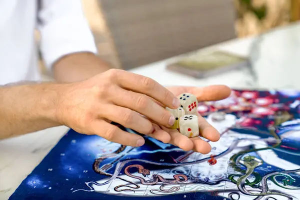 Antik Hint Oyunu Leela: Oyun Tahtasında Onyx Dice Zar ile Mens Hands 'in Yakın Çekimi, Türkiye, Alanya - 14 Nisan 2024