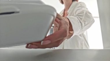 Kadın yiyecekleri buzdolabına, plastik tek kullanımlık konteynıra koyuyor, buzdolabının içinden açı, el ve kutulara yakın çekim yapıyor..