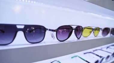 Moda aksesuarları, çeşitli renkler ve düzenli bir sunumda moda tasarımları içeren modern güneş gözlüklerinin yakın çekimi.