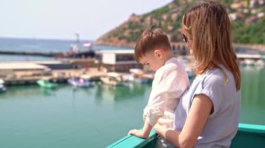 Güverte kenarında, küçük anne ve oğlu yolcu gemisinde güneşli bir yaz gününde denize açılıyorlar. Panorama 'ya hayran kalıyorlar. Aile gezisi konsepti..