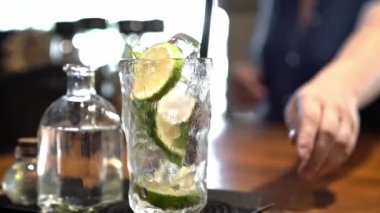 Limon kokteyli hazırlama, bar sahnesi limon dilimleri, barmen elleri ferahlatıcı yaz içeceği, barmen müşterilere servis etmek için eline tepsiyi alır..