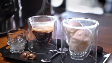 Dondurma ve çikolatalı espresso, şeffaf cam kaplama kafatası, sıcak ve soğuk zıtlığı, kasvetli tatlı kahvesinin zarif sunumu, Türkiye, Alanya, 16 Temmuz 2024.