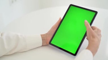 Yeşil Kroma Anahtar Ekranlı Kadın Tutma Tableti, Modern Teknolojinin Odaklı Testi, Yakın plan Beyaz Masa Parlak Ev Ayarları, Moda Kavramı .