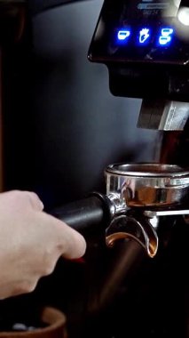 Kahve çekirdeklerini profesyonel ekipmanlarla öğütmek, hassas espresso sürecine yakın çekim, kaliteli kahve yapma, hareket halinde öğütücü, ve yetenekli hazırlık teknikleri, dikey video. 