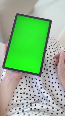 Kadın Ellerinin Kapalı Çekimi Yeşil Kromakey Ekran, Dokunaklı Ekran, Polka Dot Elbisesi Giyinme, Dijital Etkileşim, Modern Teknoloji, Ev Eğlencesi, Konforlu Atmosfer, Doğal Gün Işığı.