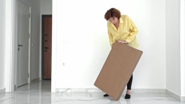 Bir kadın parlak ve havadar bir dairede yeni mobilyalarını dikkatlice açıyor. Parçaları kontrol eder ve her şeyin ev partisi için hazır olduğundan emin olmak için kolay bir toplantı hazırlar..