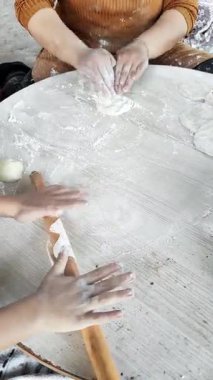 Sıcak bir mutfakta, bir anne çocuğuna pide yapma sanatını öğretir. Eller hamuru yuvarlamaya, sevgi ve öğrenme anları yaratmaya odaklanır..