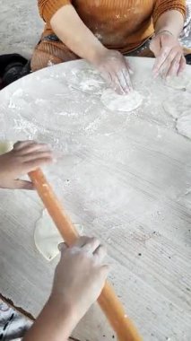 Sıcak bir mutfak ortamında, bir anne pide hamuru hazırlarken çocuğuna rehberlik eder. Birlikte un tozuyla kaplı bir yüzeye serpiştirirler. Lezzetli bir gelenek yaratırken kahkaha ve bilgi paylaşırlar..