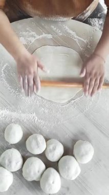 Yetenekli ellerin un tozlu bir yüzeye taze hamur dökerek leziz gözlere hazırlanmasını izleyin. Sanatçılık ve teknik bu büyüleyici mutfak anında parlıyor..