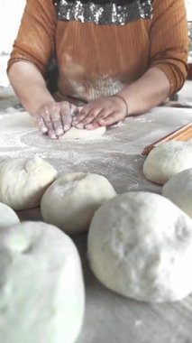Sıcak bir mutfakta, eller ustalıkla şekillendirir ve hamur yoğurur, un serpintisiyle çevrelenir, ev yapımı ekmeği sıfırdan yaratmanın sevincini gösterir..