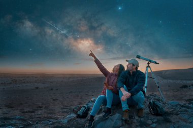 two people sitting in the desert watching the stars and Milky Way next to a telescope, stargazing and exploration concept  clipart