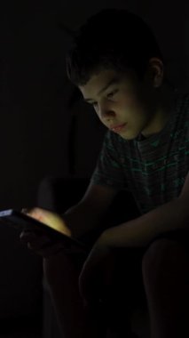 Ergen çocuk geceleri karanlık odada akıllı telefon kullanıyor. Ekran zamanı cocnept