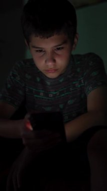 Ergen çocuk geceleri karanlık odada akıllı telefon kullanıyor. Ekran zamanı cocnept
