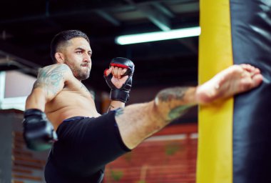 Yumruk torbasıyla güçlü İspanyol kickboksörlük eğitimi, anne eldiveni takmak, spor salonunda kickboks becerilerini geliştirmek.