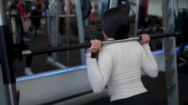 Latin Amerikalı kadın halterle egzersiz yapıyor. Spor salonunda kulaklıkla müzik dinliyor. Yas tutma rutini ve sağlıklı yaşam tarzı kavramı. 