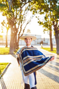 Sokakta Şili huaso kostümü giymiş Latin Amerikalı genç bir yetişkin portresi.