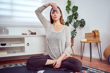 Güzel beyaz kadın yüzüne elle masaj yapıyor. Kuvars masaj aleti, yüz yogası ve yaşlanma karşıtı.