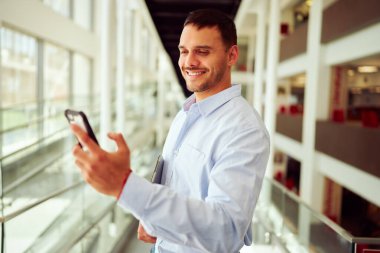 Ofiste tablet tutarken cep telefonuyla mesaj atan mutlu girişimci
