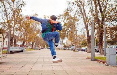 Latin Amerikalı break dansçı sokakta ayak hareketleri ya da toprock yapıyor.
