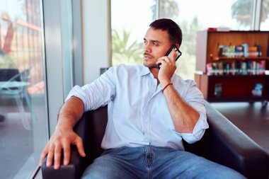 Girişimci, modern bir ofiste dizüstü bilgisayarı üzerinde çalışırken iş görüşmesi yapıyor.