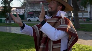 Geleneksel huaso kıyafetleri giymiş bir çiftin portresi şehir meydanındaki cueca ritmine alkış tutuyor.