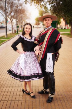 Şehir meydanında geleneksel huaso kostümlü heteroseksüel çift portresi, Fiestas Patrias Şili kutlamaları konsepti