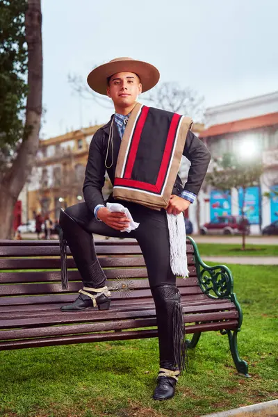 Şilili Huaso kostümlü bir gencin portresi meydanda poz veriyor, Şili Patrias kutlamaları.