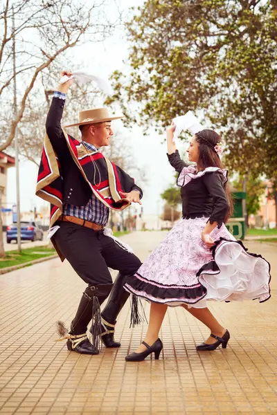 Şehir meydanında Şili Cueca dansı yapan bir çift huasonun portresi. 