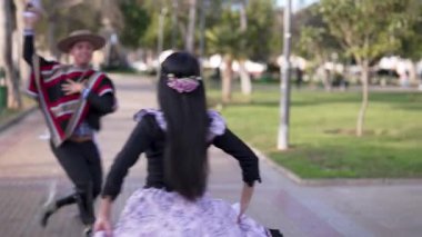 Şehir meydanında dans eden iki huaso, Şili cuecası, patrias kutlaması 