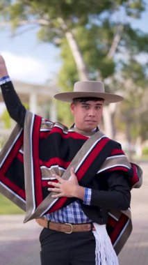 Şilili Huaso kostümlü bir gencin portresi meydanda poz veriyor, Şili Patrias kutlamaları.