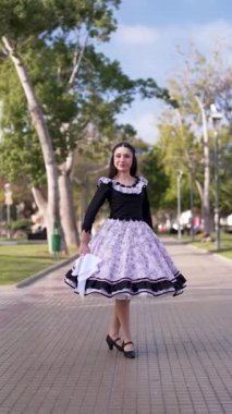 Şilili Huaso kostümlü genç bir kadının portresi meydanda poz veriyor, Şili Patrias kutlamaları.