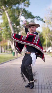 Şilili Huaso kostümlü bir gencin portresi meydanda poz veriyor, Şili Patrias kutlamaları.