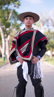 Şilili Huaso kostümlü bir gencin portresi meydanda poz veriyor, Şili Patrias kutlamaları.