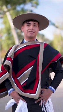 Şilili Huaso kostümlü bir gencin portresi meydanda poz veriyor, Şili Patrias kutlamaları.