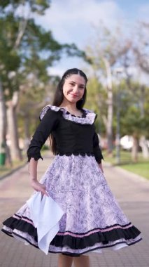 Şilili Huaso kostümlü genç bir kadının portresi meydanda poz veriyor, Şili Patrias kutlamaları.