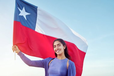 Şili 'nin açık havada mavi gökyüzüne karşı bayrak tutan güzel bir kadın, kutlama ve vatanseverlik kavramı